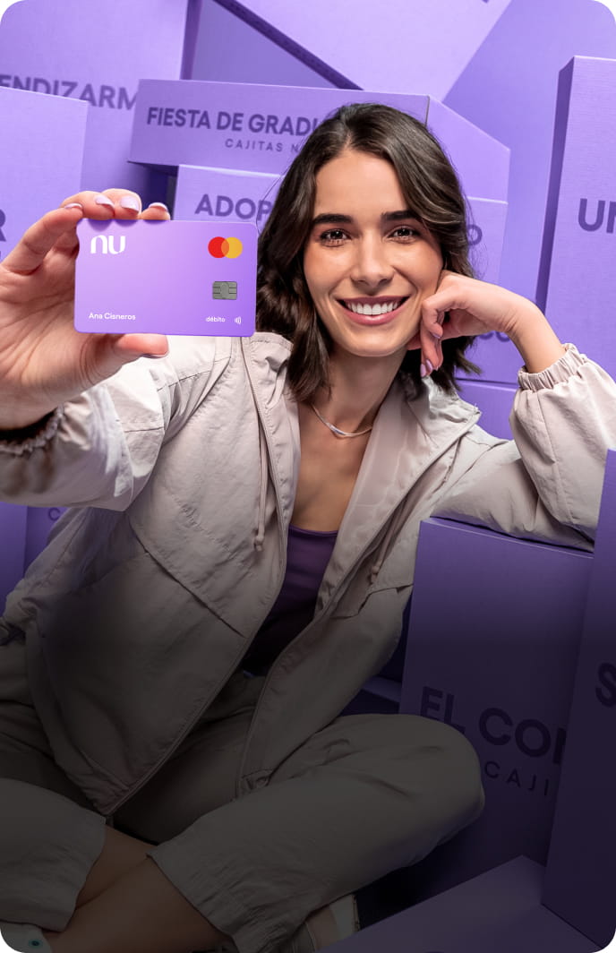 Una persona sonriendo mientras sostiene una tarjeta morada